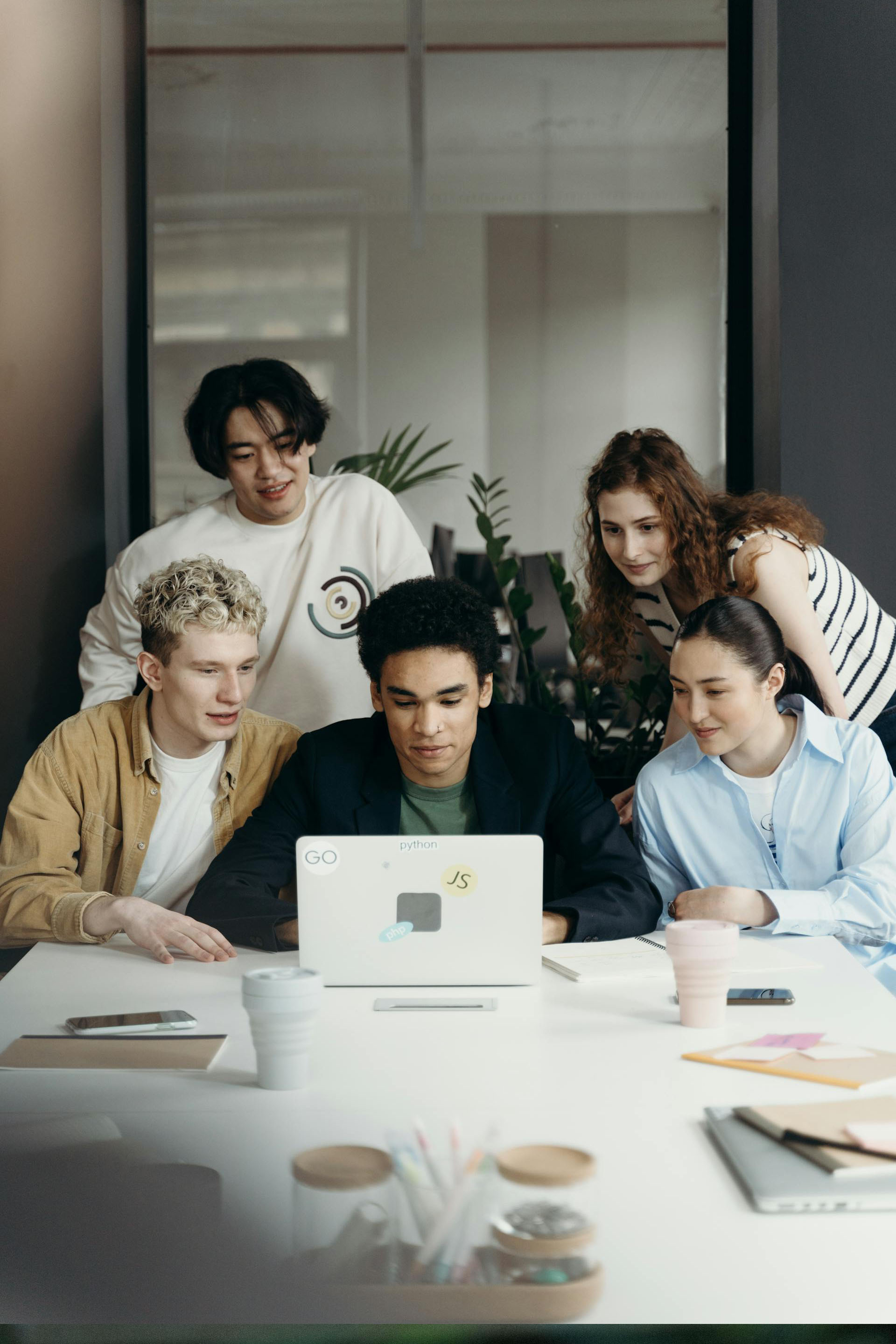 5 people looking at a laptop